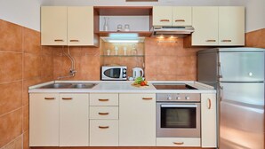 A kitchen with a microwave, stove, and refrigerator.