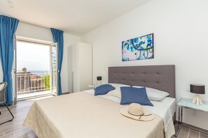A hotel room with a bed, a balcony, a painting, and a nightstand. - Hedera Estate, Villa Hedera V (Dubrovnik)