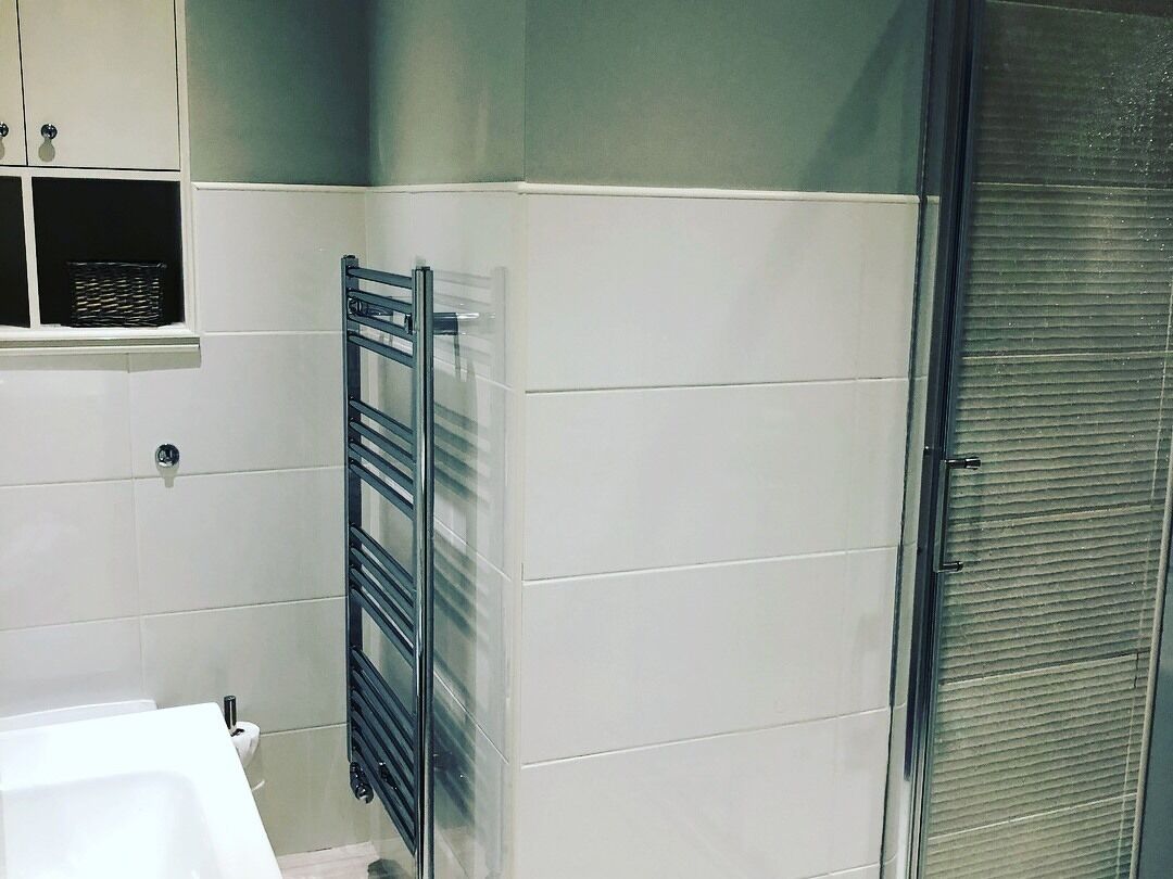 Une salle de bain avec un lavabo blanc, un porte-serviettes et des toilettes.