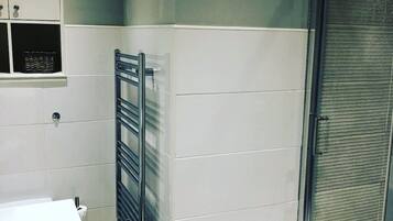 Une salle de bain avec un lavabo blanc, un porte-serviettes et des toilettes.