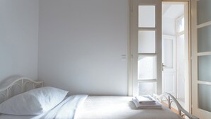 A room with a bed, white walls, and a door leading to another room. - Hedera Estate, Hedera A27 (Dubrovnik)