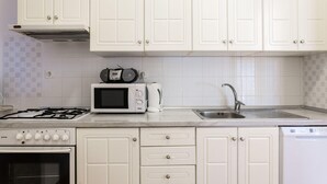 A kitchen with white cabinets, a microwave, a gas stove, a dishwasher, and a sink. - Hedera Estate, Hedera A27 (Dubrovnik)