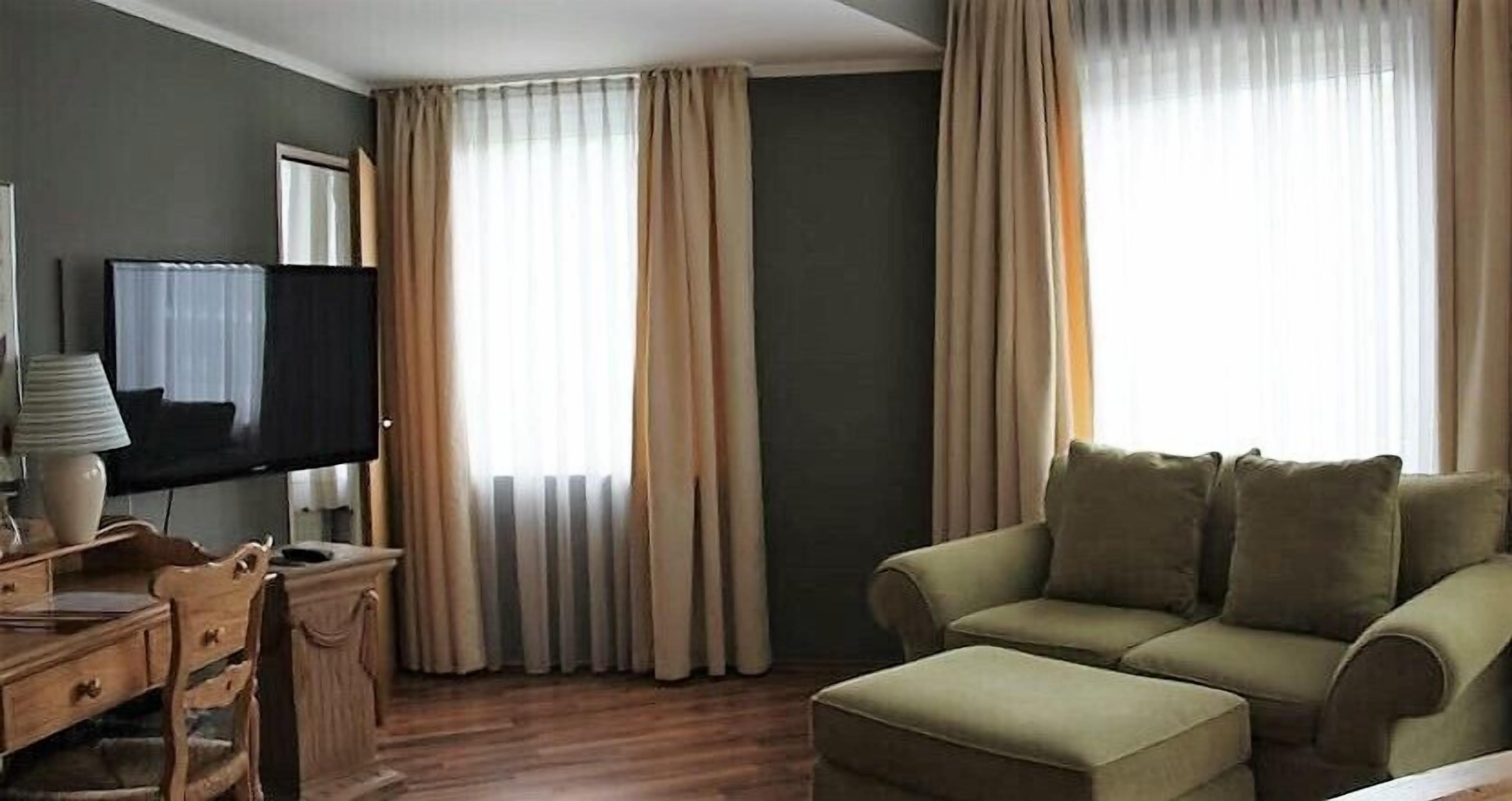A living room with a sofa, a television, and a wooden table.