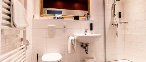 A modern bathroom with a toilet, sink, and shower.