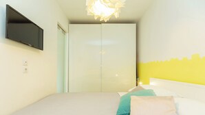A bedroom with a bed, a flat-screen TV mounted on the wall, and a wardrobe. - Hedera Estate, Hedera A29 (Dubrovnik)