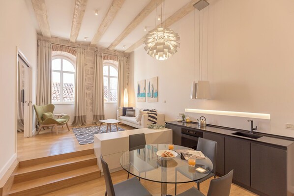A modern apartment with a dining area, kitchen, and living space.