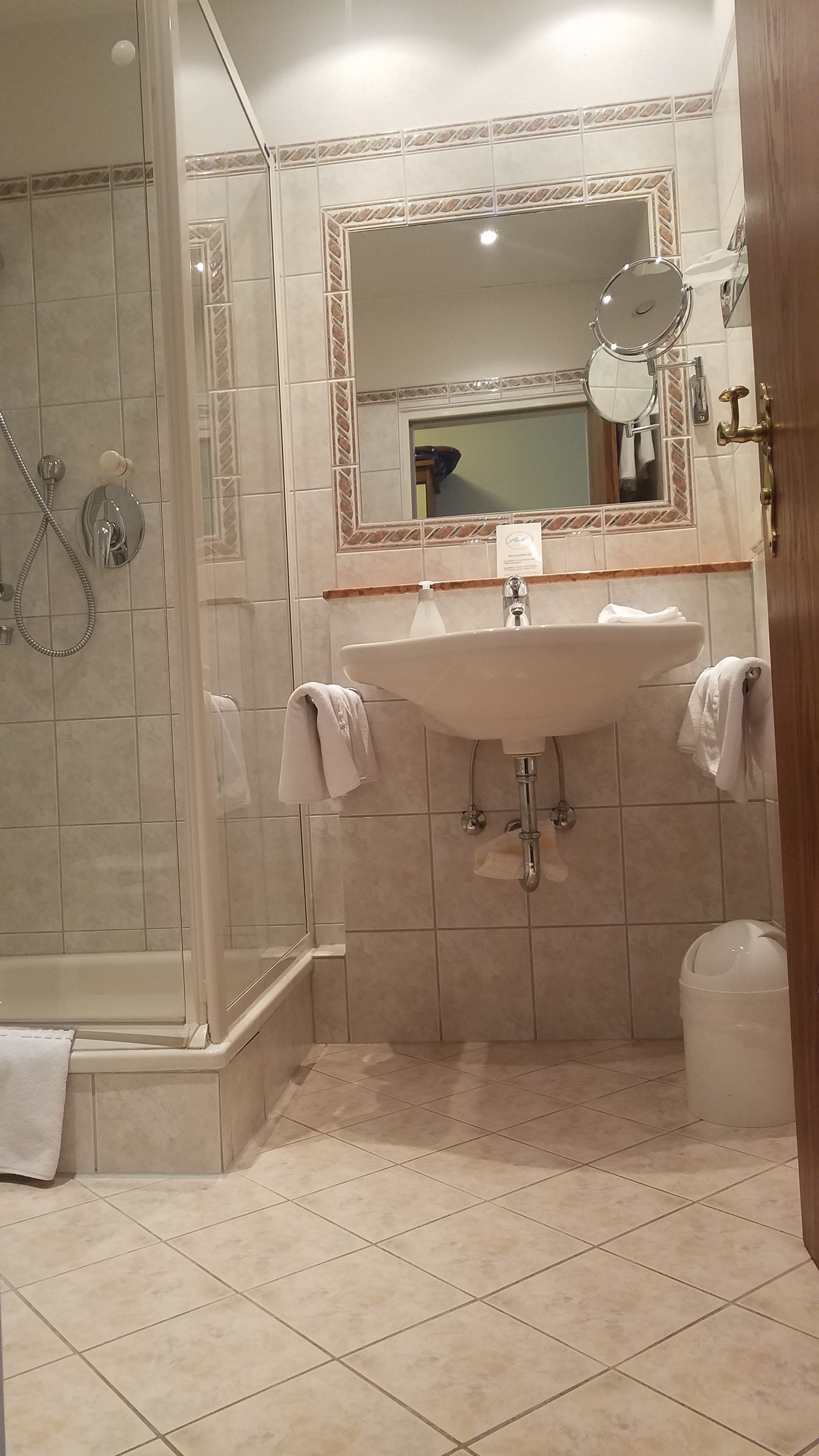 A bathroom with a shower, a sink, and a mirror.