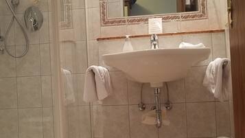 A bathroom with a shower, a sink, and a mirror.