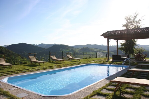 Una piscina al aire libre de temporada, sillones reclinables de piscina