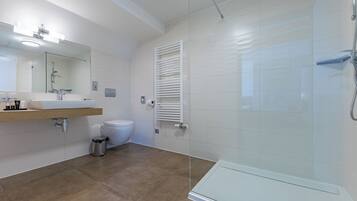 A modern bathroom with a sink, toilet, and glass shower enclosure.