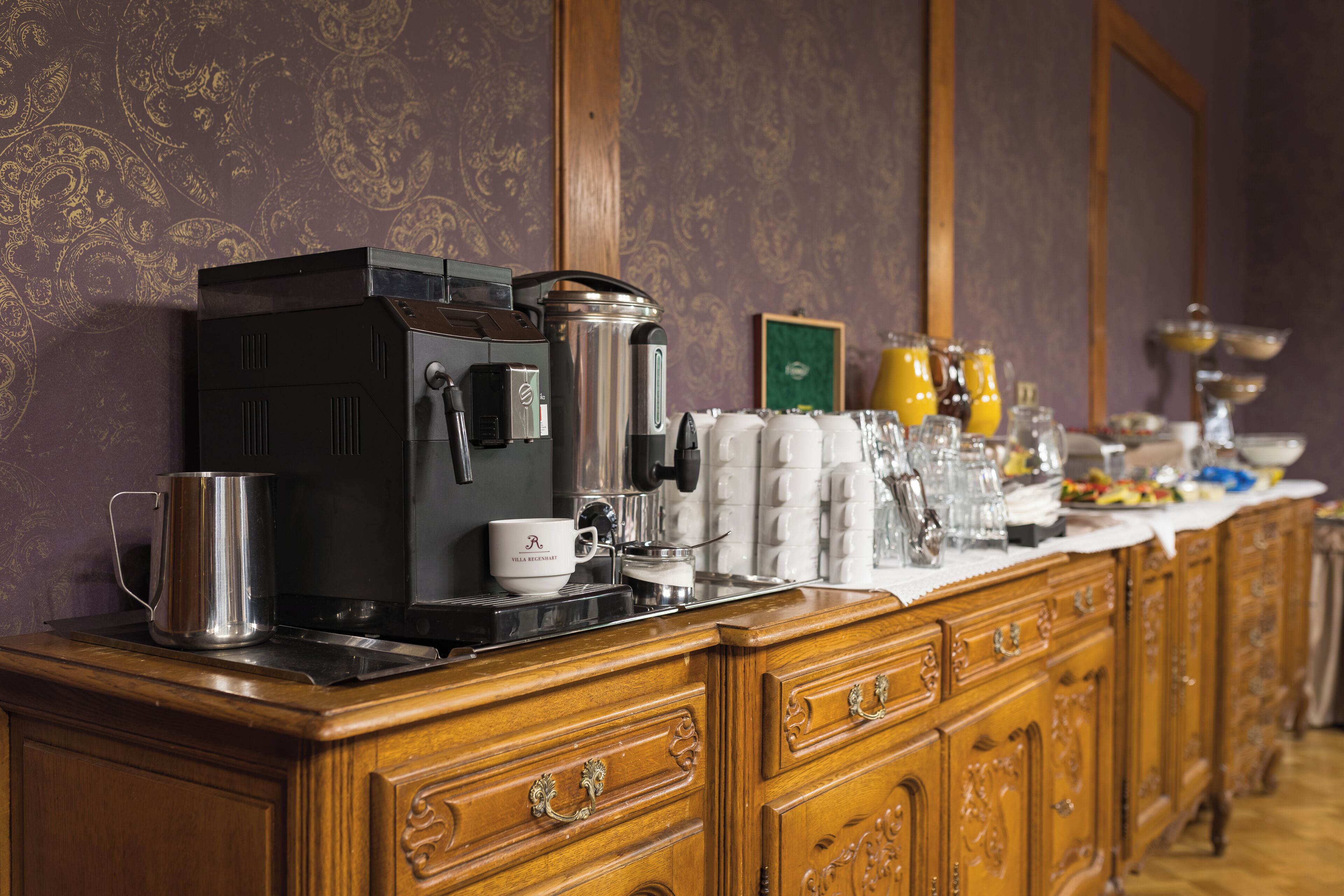 Un buffet per la colazione con macchine da caffè, teiere e diverse bevande.