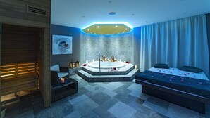 Uma sala de spa moderna com hidromassagem, mesa de massagem e área de estar.