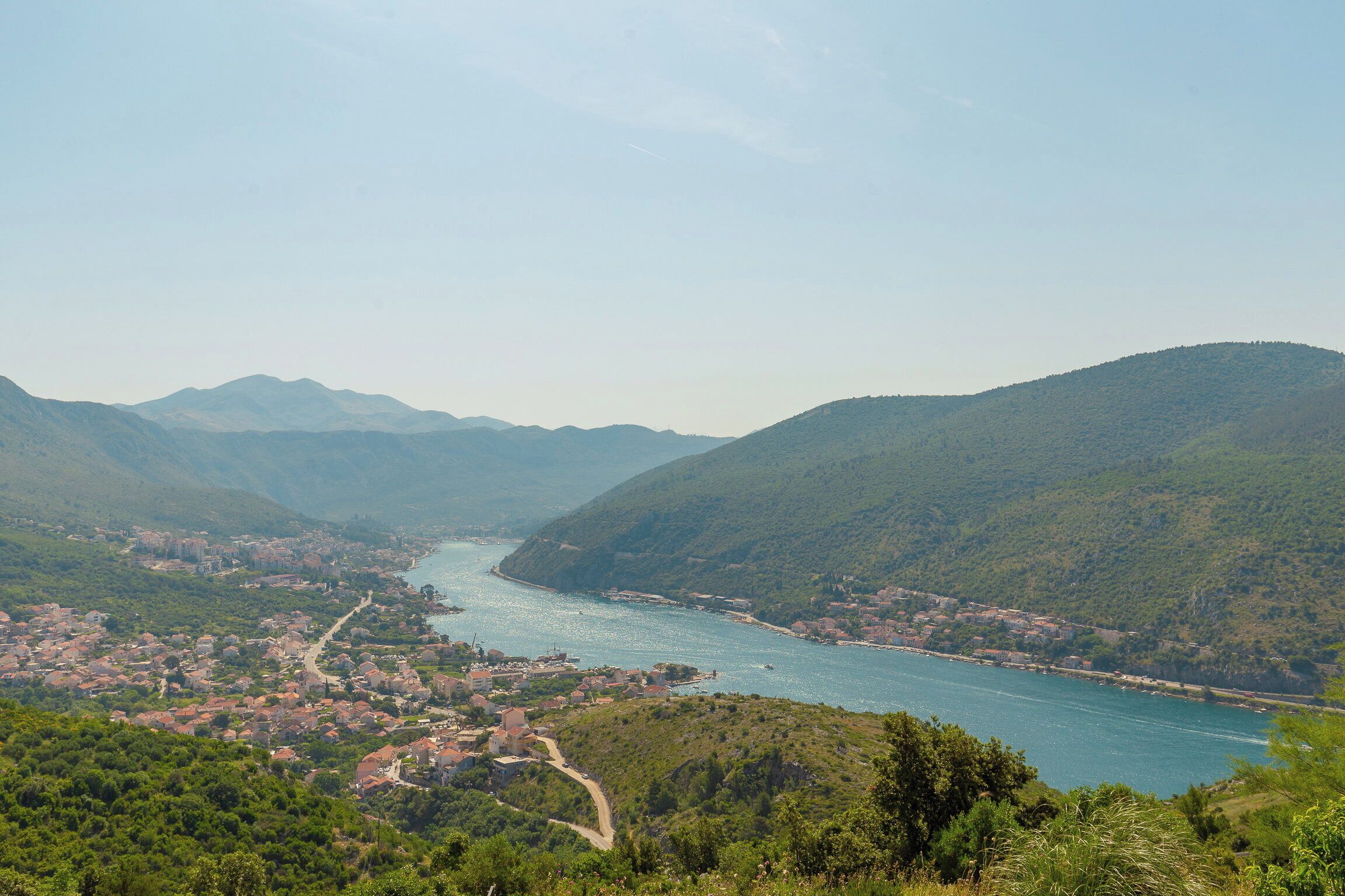 A coastal town with a river, surrounded by hills.