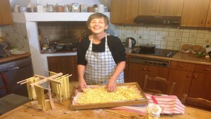 Una cocina con armarios de madera, una estufa y una persona preparando comida.