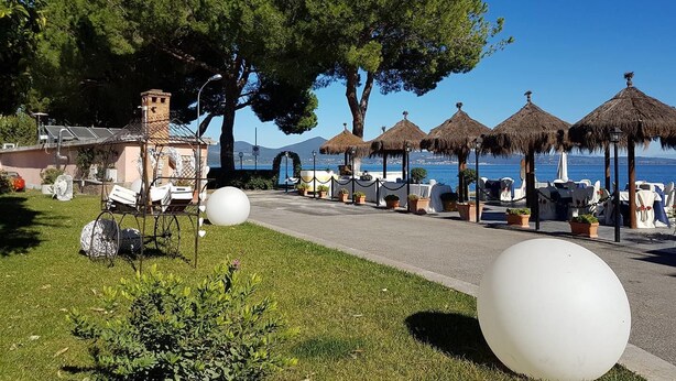 Ein Hotel an der Küste mit Terrassenmöbeln, freiem Blick auf das Meer und einem gepflegten Garten.