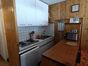 A kitchen with white cabinets, a stainless steel toaster, and a wooden countertop.