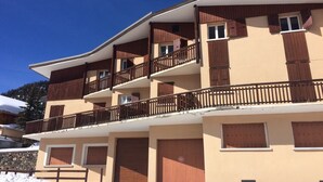 Un immeuble à plusieurs étages doté de balcons et de grandes portes de garage.