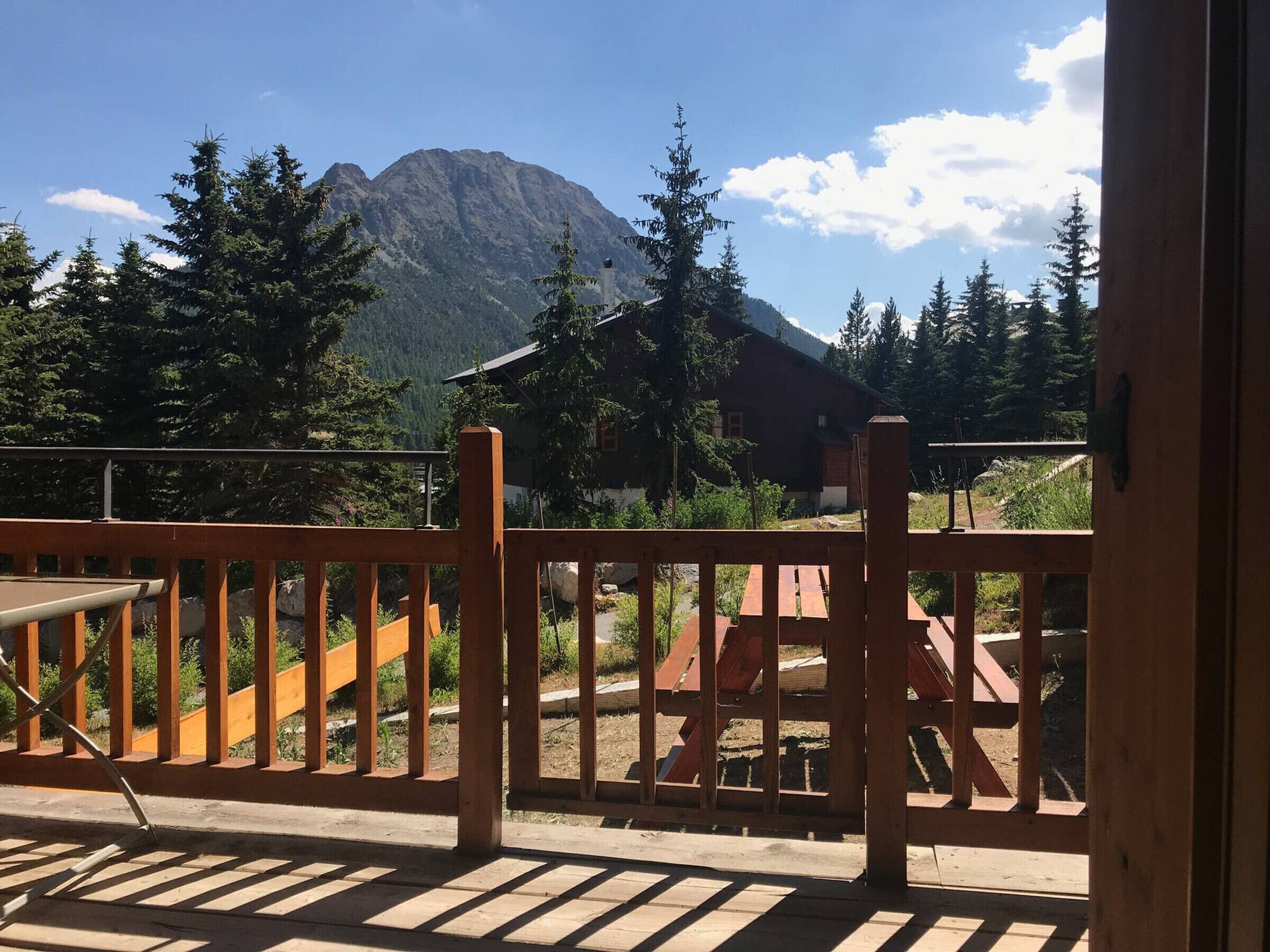 A wooden deck with a view of a mountain and a building in the background.