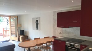 A modern kitchen with red cabinets, a dining table with chairs, and a large window. - Lovely apartment 6 people, terrace, garage, pets welcome (Montgenèvre)