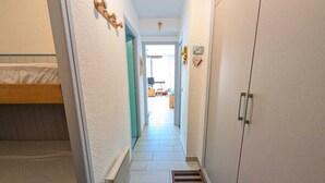 A narrow hallway with a bunk bed on the left, a radiator, and a wardrobe on the right. - Studio with south-facing balcony, parking in Montgenèvre, pets allowed (Montgenèvre)