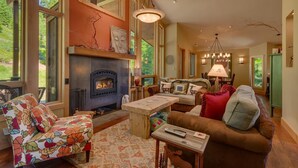 Ein gemütliches Wohnzimmer mit Kamin, großen Fenstern und einem Essbereich.