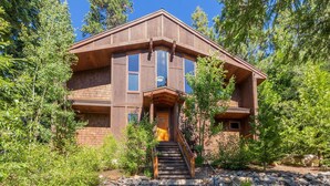 Ein zweistöckiges Haus mit Steinunterbau, einer Holztreppe und einer Veranda.