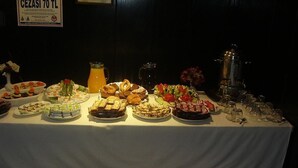 Ein Buffet mit verschiedenen Speisen und einem Krug Orangensaft.
