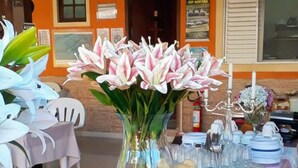 A buffet table with various dishes and a vase of flowers. - Pousada Quatro Estações Paraty (Paraty)