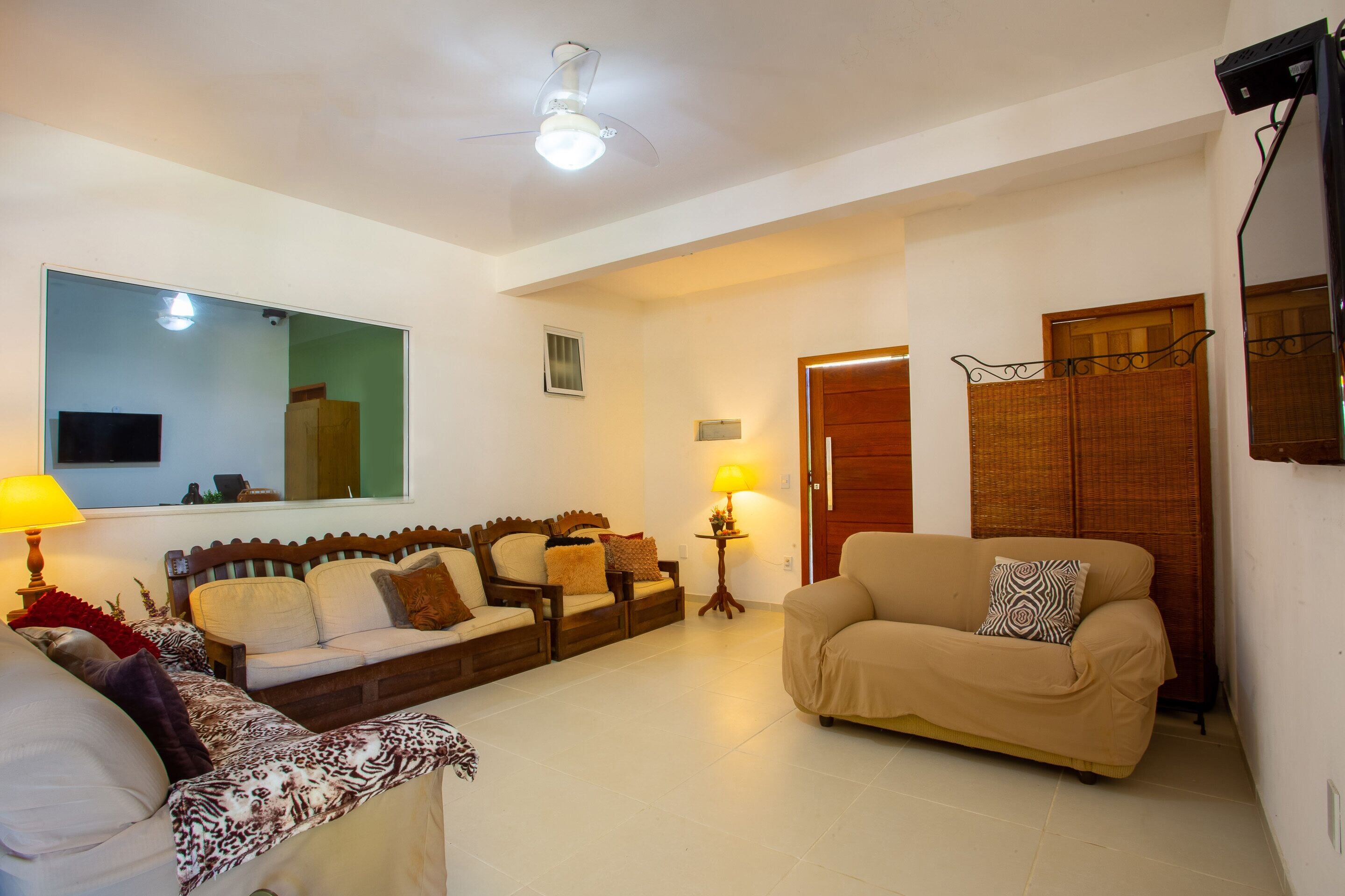 Una sala de estar con un sofá, dos sillones, una mesita de centro y un televisor.