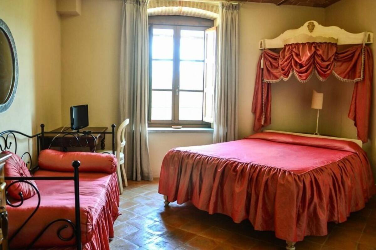 A bedroom with a bed, a desk, and a chair.
