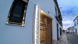 A building with a large wooden door and a window with shutters.