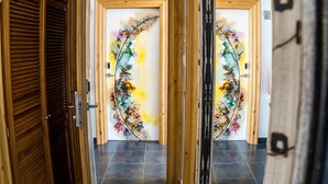 A hotel room with a wooden door and a view of the street outside.