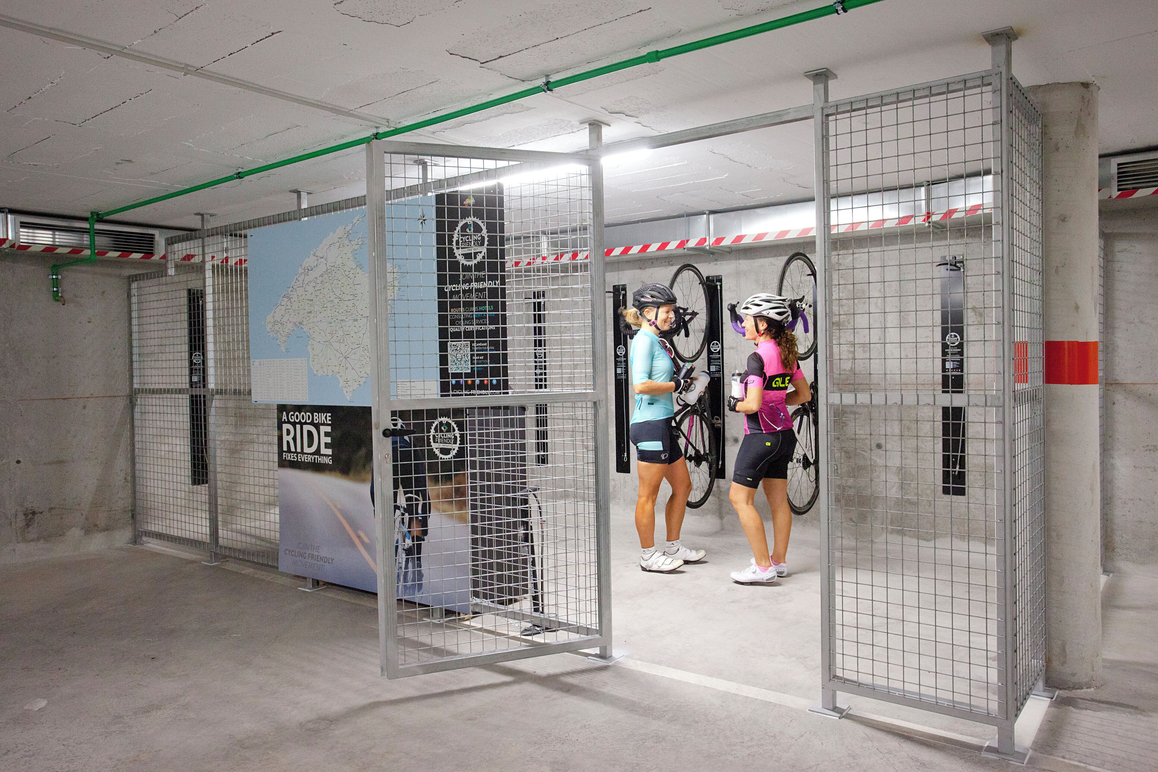 Un espace de stationnement pour vélos, délimité par des barrières métalliques, et une carte affichée sur le mur.