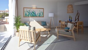Una sala de estar moderna con sofá, sillas, una mesa de centro y un comedor.
