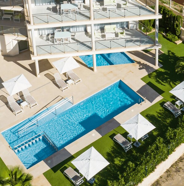 Una piscina al aire libre de temporada, sombrillas