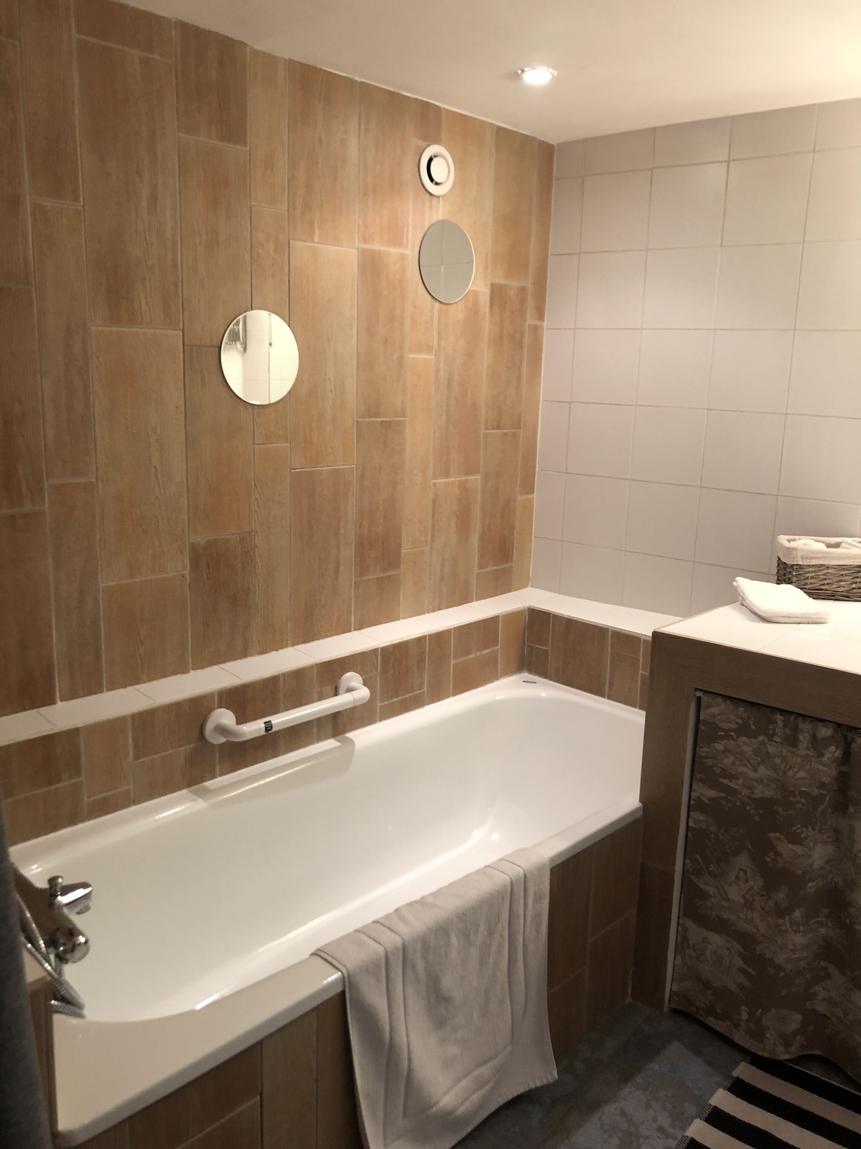 Un baño moderno con una bañera independiente, un perchero para toallas y un inodoro.
