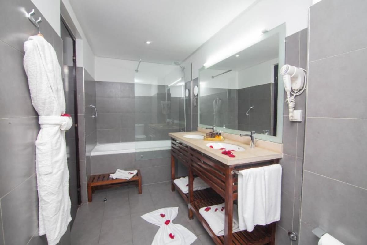 A modern bathroom with a glass-enclosed shower, a double sink vanity, and a large mirror.