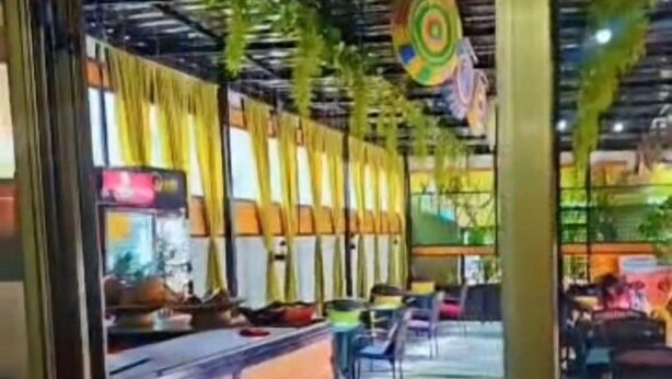 Un restaurante interior con mostradores de madera y decoraciones colgantes.