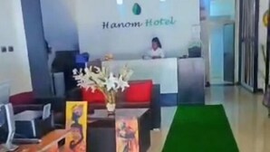 Un área de recepción con un mostrador, sillas y una alfombra verde.