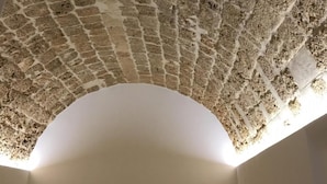 A stone vaulted ceiling with a decorative keystone at the apex. - B&B Macrina (Noto)