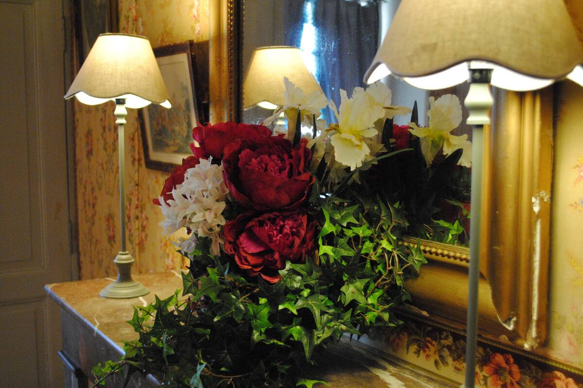 A floral arrangement with a mirror and lamps.