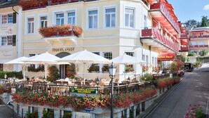 A hotel with outdoor seating, flower boxes, and a sign for 'Hotel Post'. - Wellness Privathotel Post an der Therme (Badenweiler)