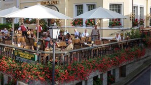 A hotel with outdoor seating, red flower boxes, and a sign for 'HOTEL POST'. - Wellness Privathotel Post an der Therme (Badenweiler)