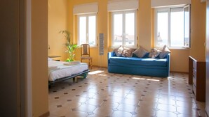 Una habitación con una cama, un sofá azul y una planta.