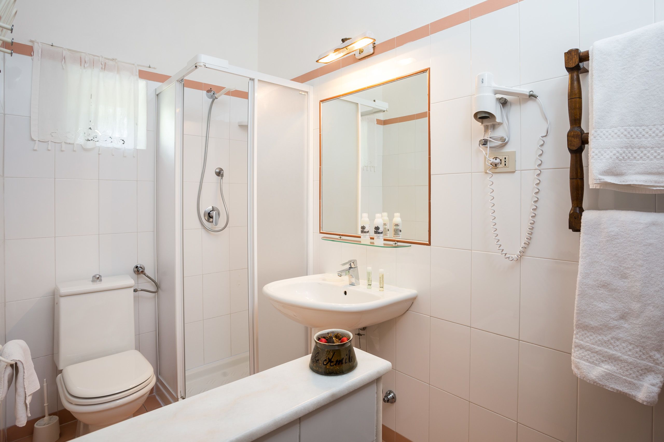 Une salle de bain avec des toilettes, un lavabo et une douche.