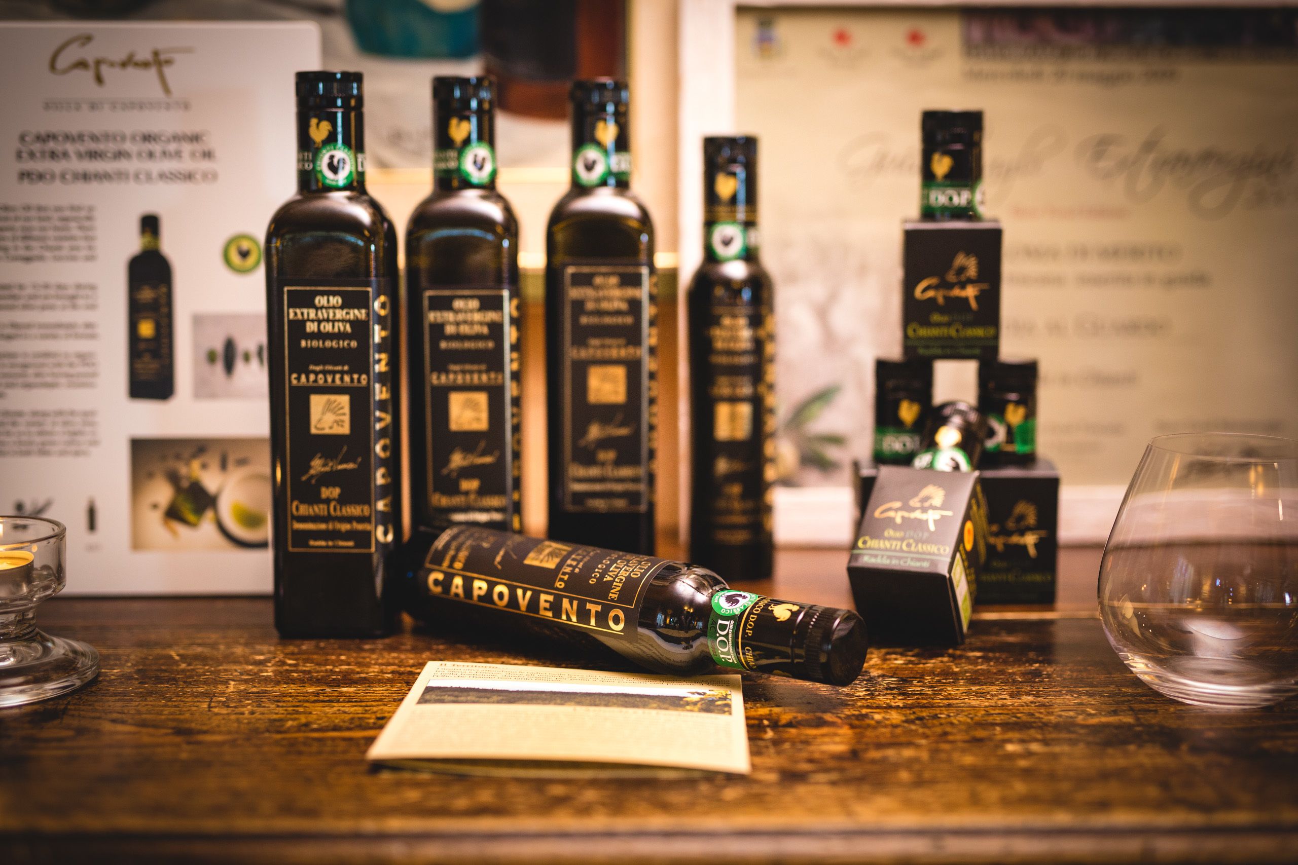 A selection of olive oil bottles and boxes on a wooden table.