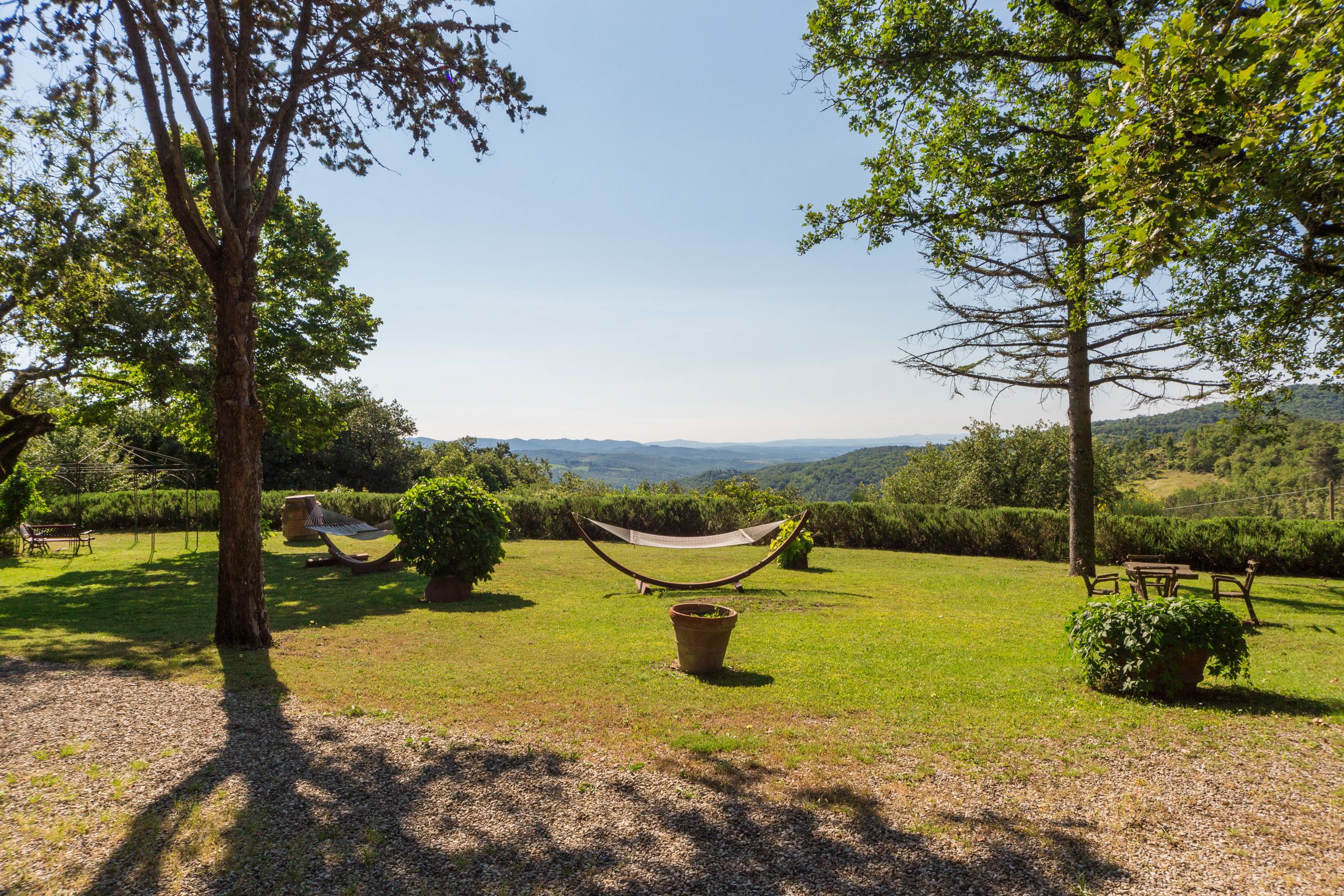 A hammock in a grassy area with a view of distant hills.