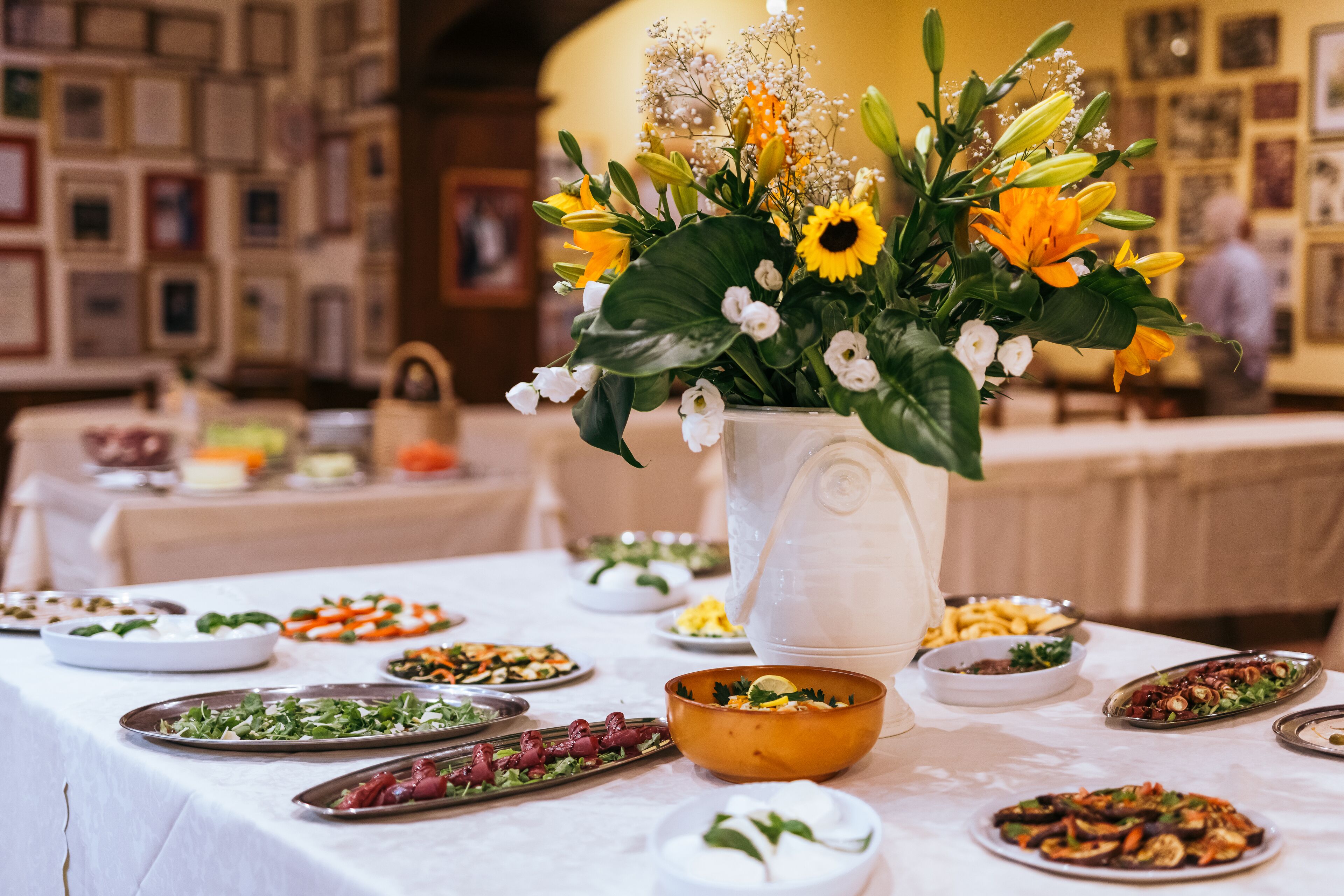 A dining table with various dishes and a centerpiece of flowers.