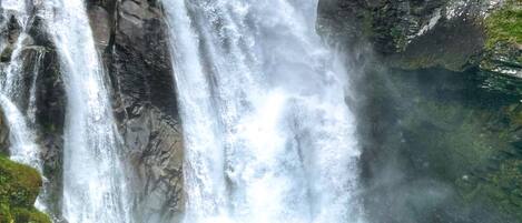 A waterfall cascading down a rocky cliff into a clear pool of water.