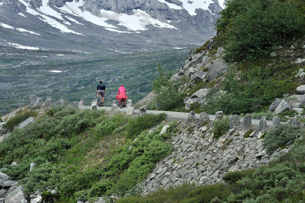Eine gebirgige Landschaft mit einem asphaltierten Weg und felsigem Gelände.